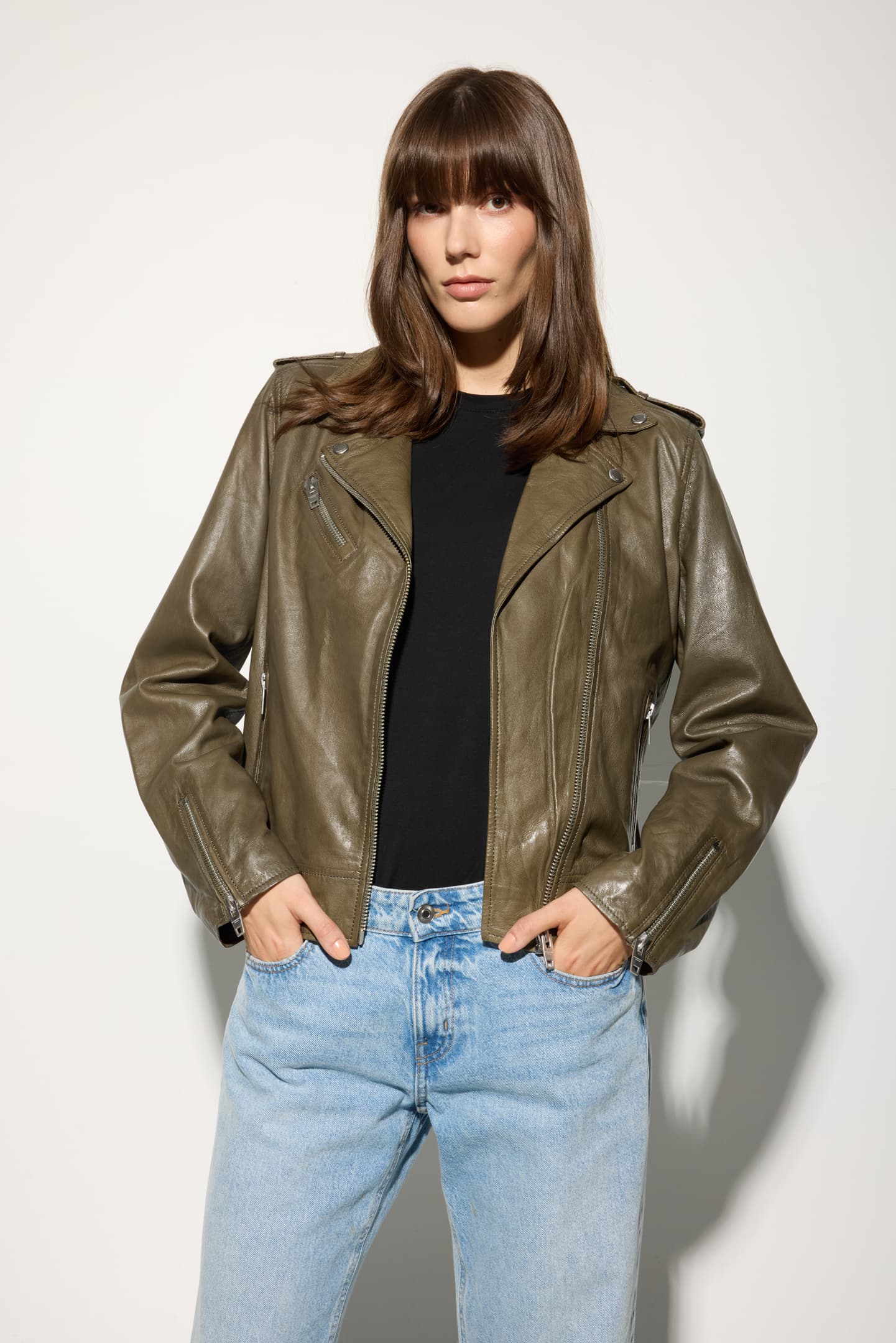 Model wearing the Yaya leather jacket in dusty olive, angled front view.
