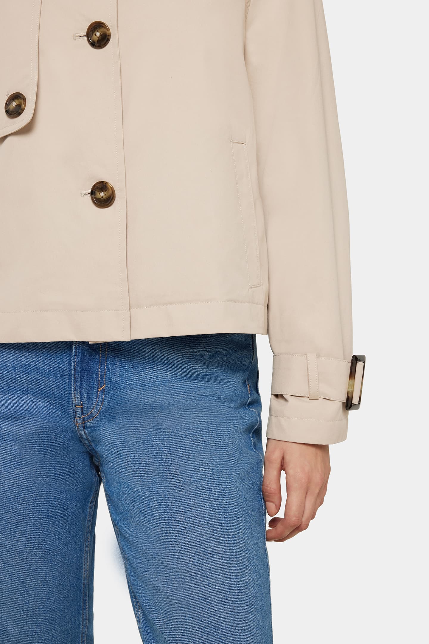 Close-up of the Serafina jacket in classic beige, showing the front buttons, side pocket, and belted cuff detail.