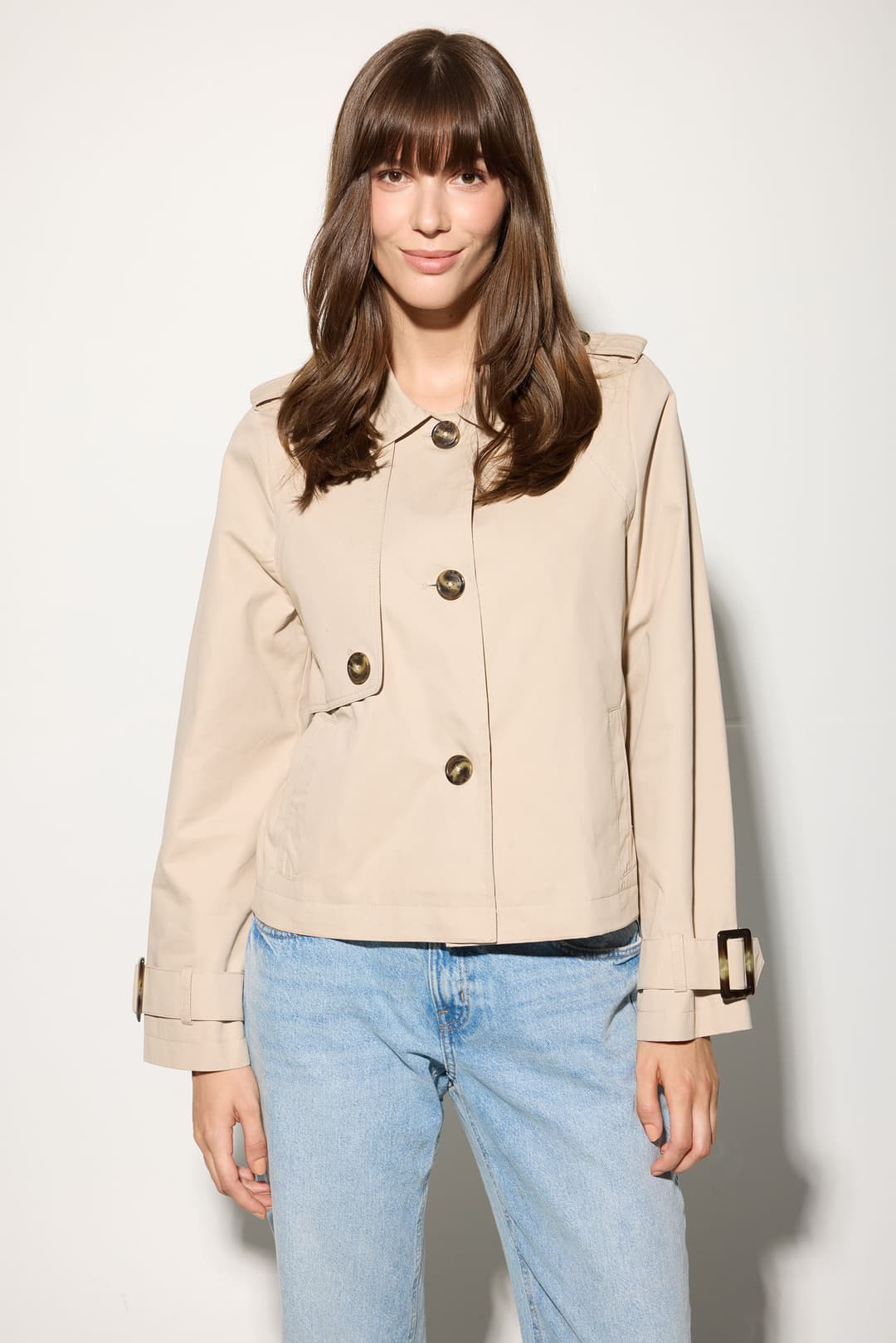 Model wearing the Serafina jacket in classic beige, front view with arms relaxed and jacket buttoned up.